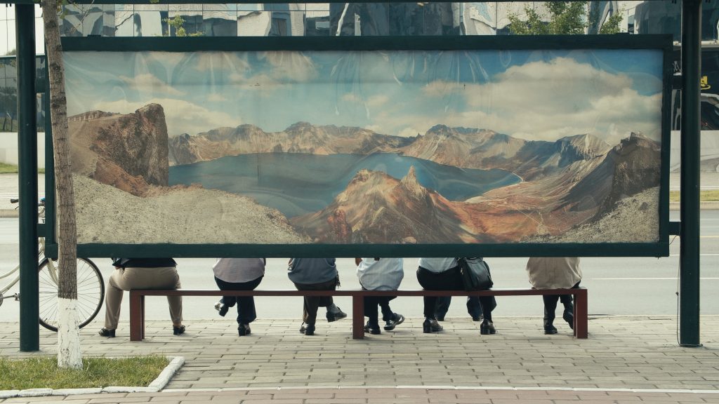 This image has an empty alt attribute; its file name is Bern_-Pyongyang-bus-stop-film-still-©Katharina-Schelling-Swiss-Alpine-Museum-1024x576-1.jpg